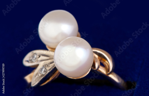 gold ring with pearls close-up on blue photo