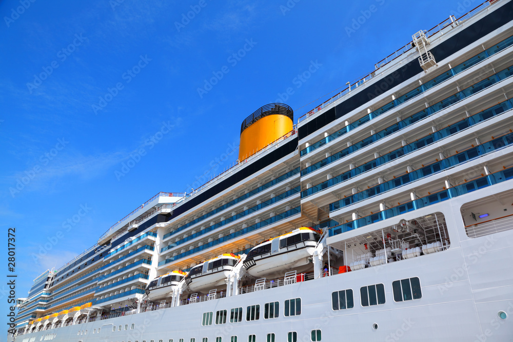 Large cruise ship with yellow funnel and blue balcony