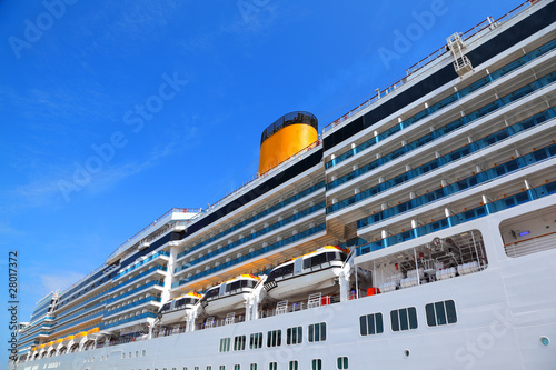Large cruise ship with yellow funnel and blue balcony