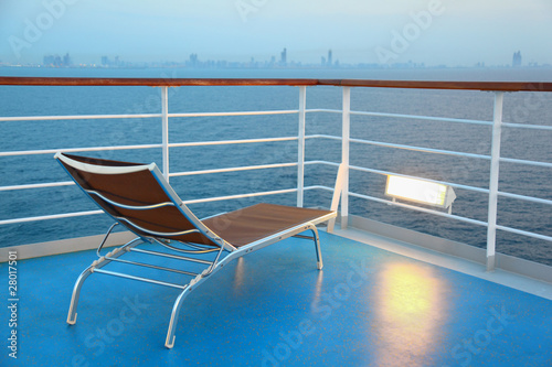 Illuminated solitary highlighted deck-chair on ship overlooking