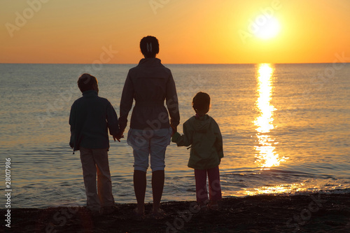 Quadro em tela Mother with two children, embarking on hands stand on beach