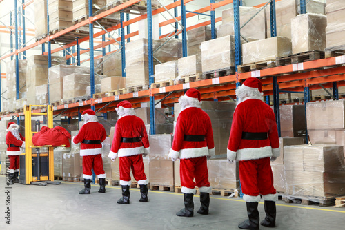 Tableau sur toile santa clauses  in the line for the sacks of gifts in storehouse
