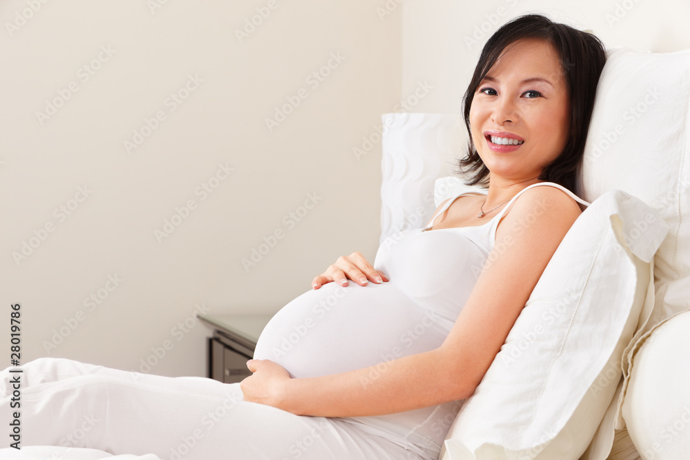 Pregnant lady resting on bed Pregnant lady resting on bed