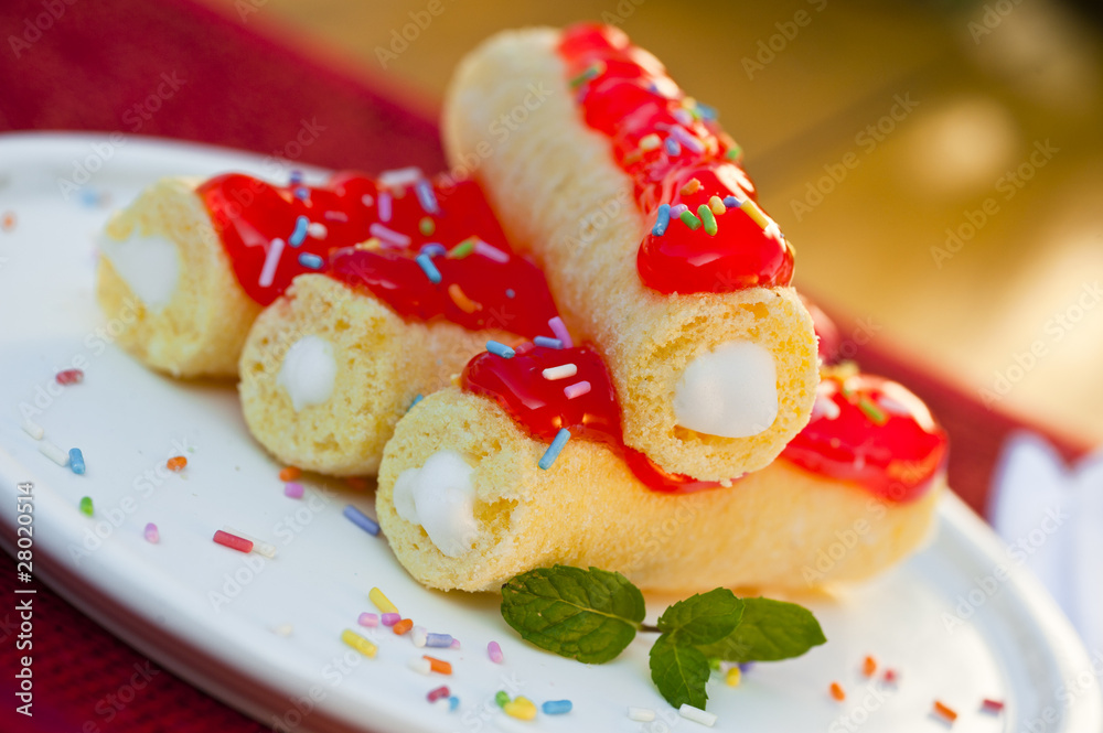 Delicious cream rolls with strawberry sauce