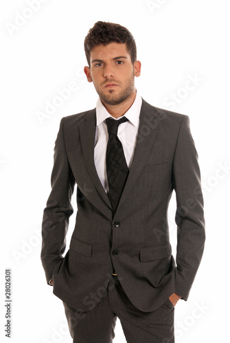 Young businessman looking serious hands in pockets isolated