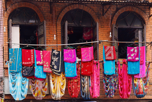 Storefront of old nepal textile shop with many multicolored garm