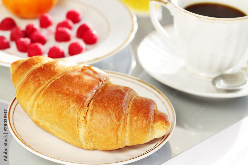 Breakfast. A cup of coffee, croissant and berries
