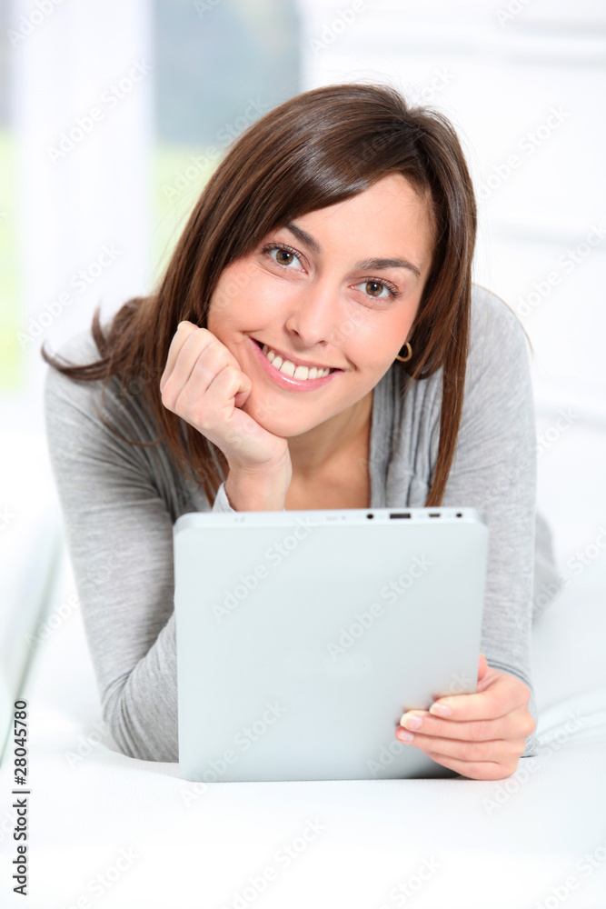 Young woman laying on sofa with electronic pad Young woman laying on sofa with electronic pad