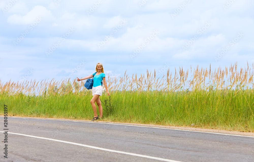 Obraz premium Hitchhiking girl votes on road