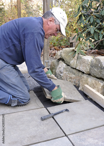 Man installs flagstone pavers on patio