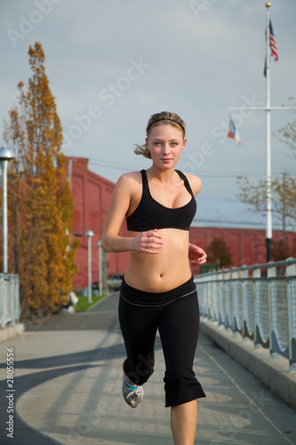 Young blonde female running on a pier
