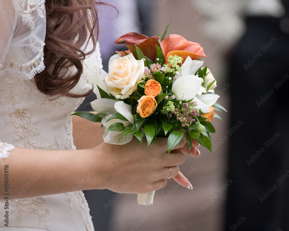 Wedding bouquet from roses in hands at the bride