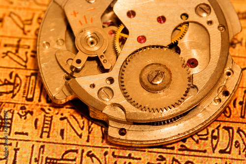 Antique watch mechanism on Egyptian text background