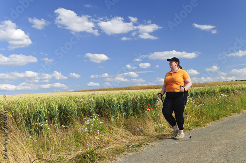 XXL-Model übergewichtige Frau beim Nordic Walking