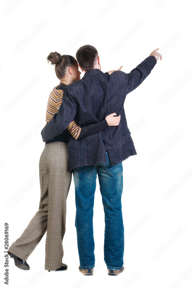 Young couple pointing at wall. Rear view. Isolated over white ba