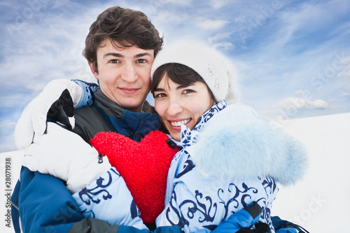 Smiling girl in blue embrase red heart and her friend photo