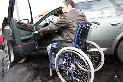 Young man in wheelchair getting in his car © goodluz
