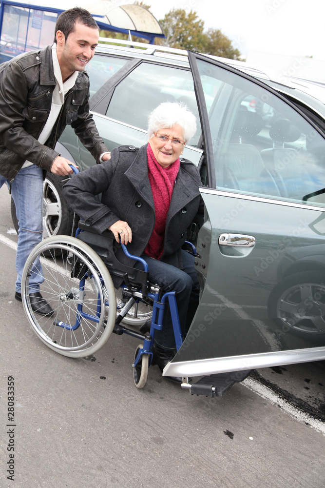 Young man assisting senior woman in wheelchair Young man assisting senior woman in wheelchair