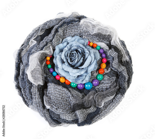 Varicoloured scarf is put with necklace around and flower photo