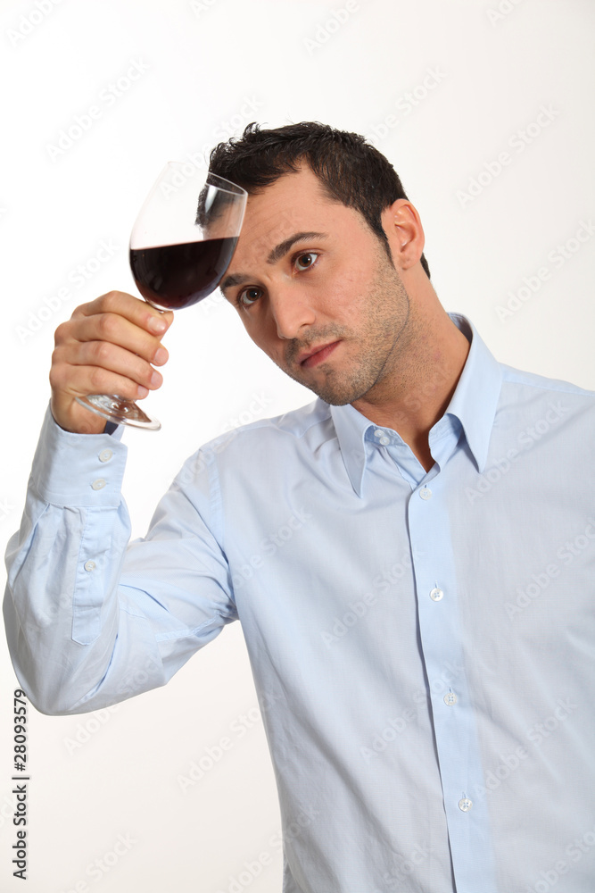 Young man on white background tasting red wine
