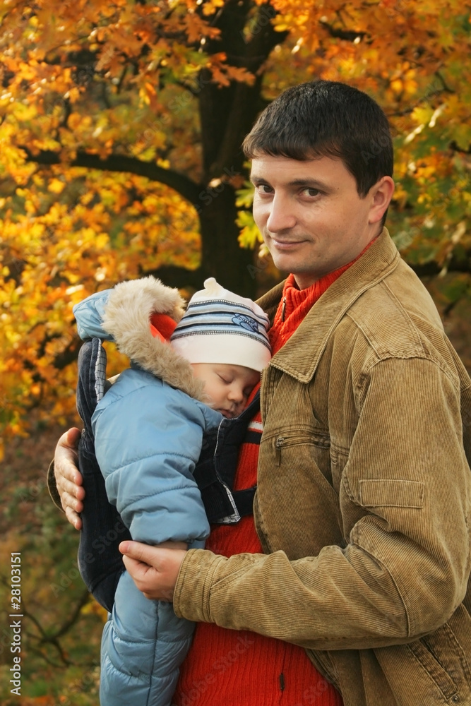 father holding his son in baby carrier father holding his son in baby carrier