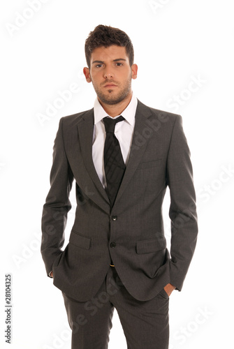 Young businessman looking serious hands in pockets isolated