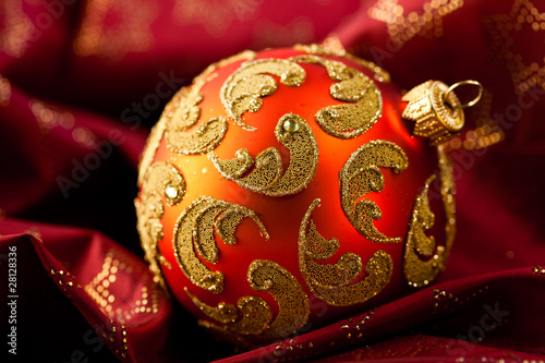 Closeup of a beautiful christmas ball on red satin