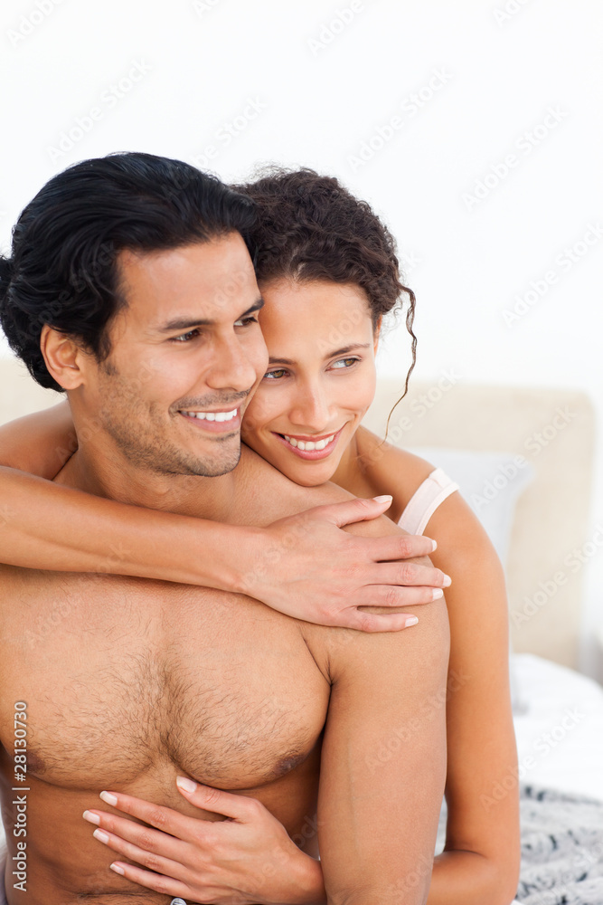 Passionate woman hugging her boyfriend sitting on their bed Passionate woman hugging her boyfriend sitting on their bed