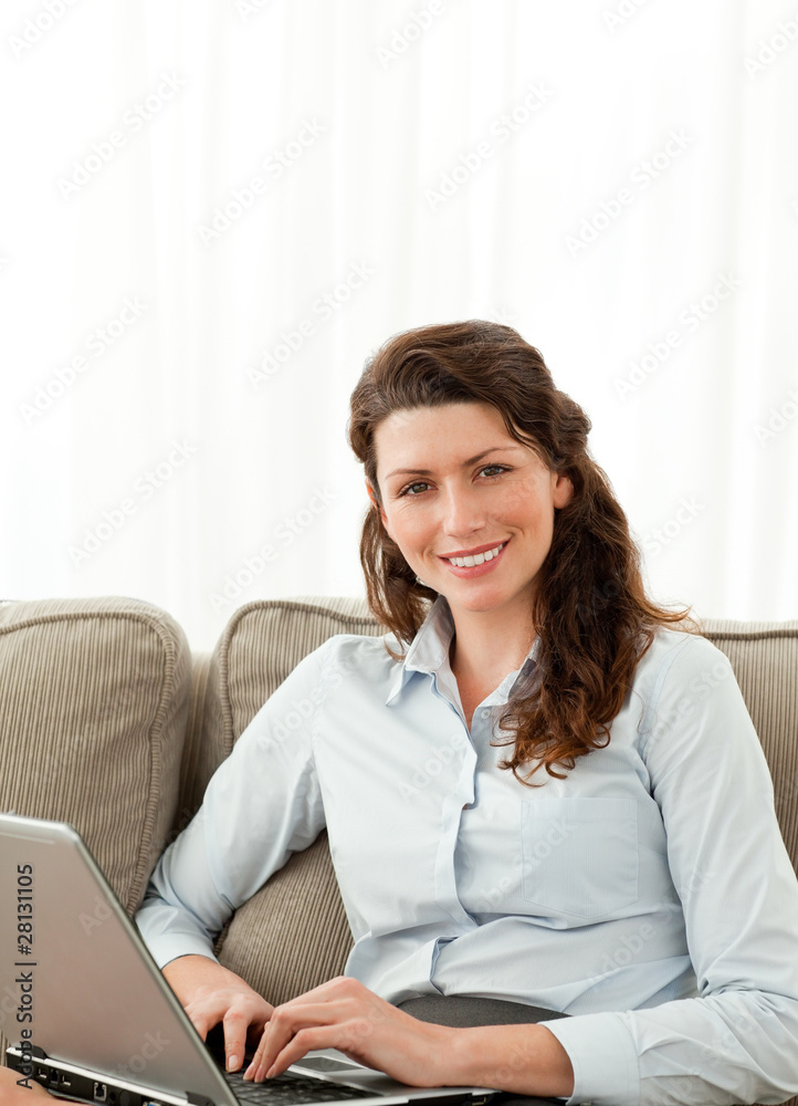 Pretty businesswoman working on the sofa with her laptop Pretty businesswoman working on the sofa with her laptop