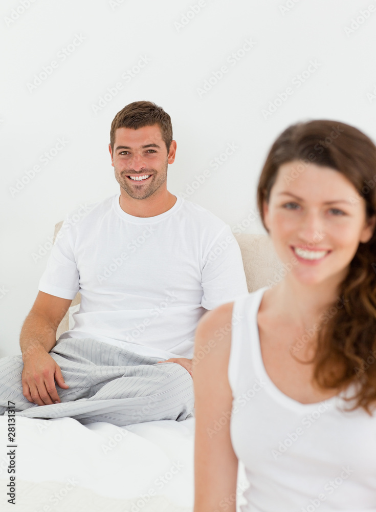 Cheerful couple relaxing together in their bedroom in the mornin Cheerful couple relaxing together in their bedroom in the mornin