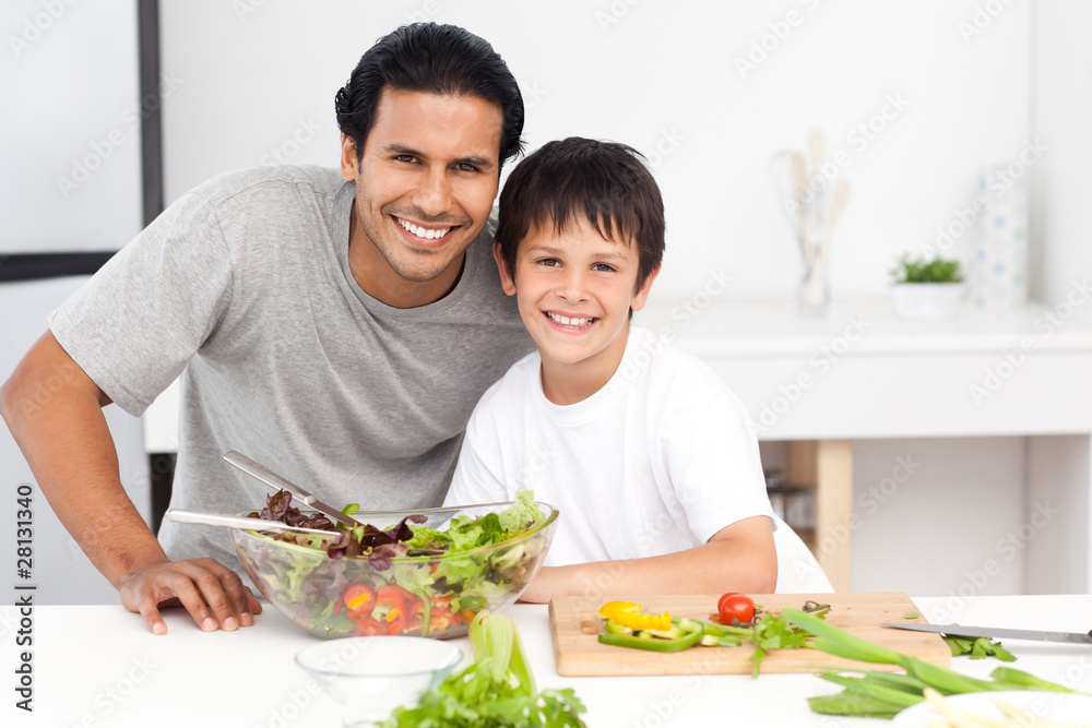 Portrait of a father and his son preparing a salad in th kitchen Portrait of a father and his son preparing a salad in th kitchen
