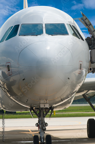 Closeup of airplane nose with pilot cabin against blue sky