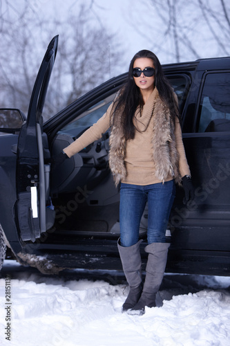Beautiful woman in car in snowy winter outdoors