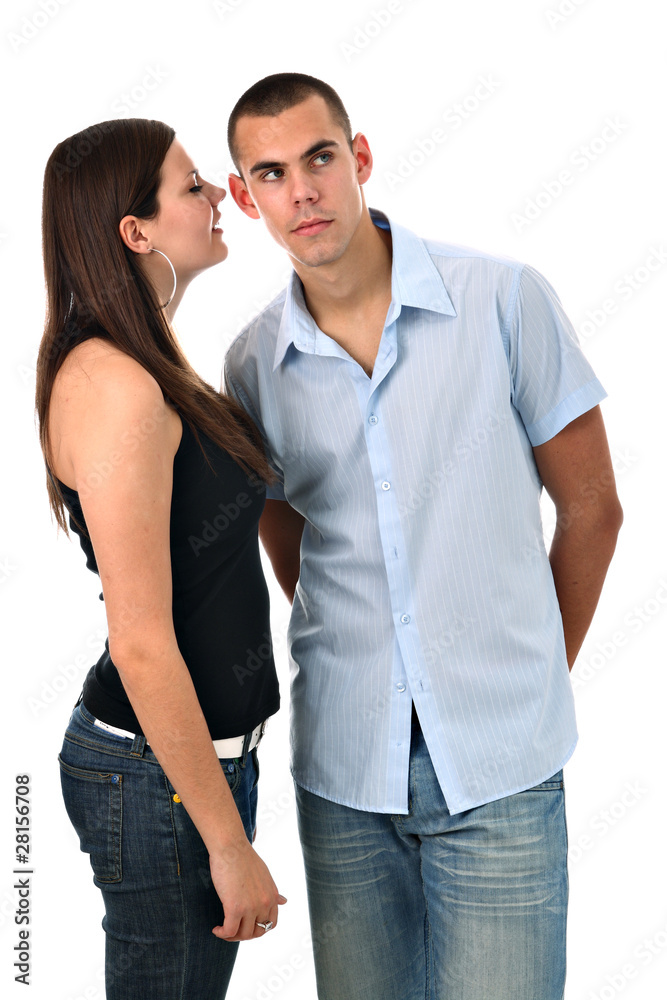 Girl whispers into her boyfriend's ear isolated on white Girl whispers into her boyfriend's ear isolated on white