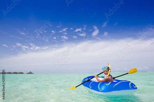 Boy paddling rubber raft