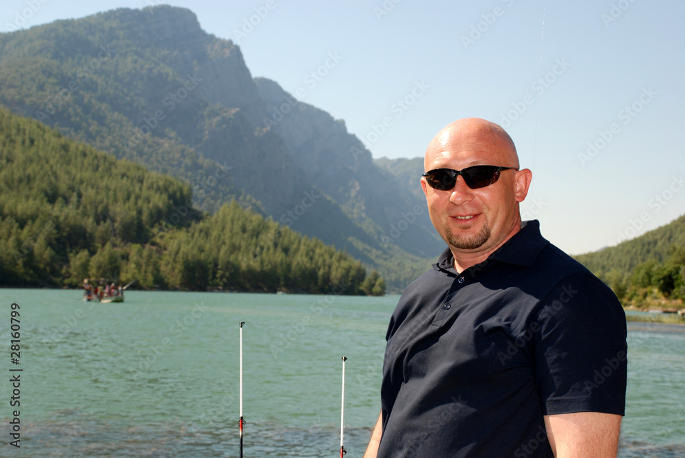 fisherman in sunglasses on the lake