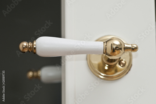 White and golden door handle made of wood and metal