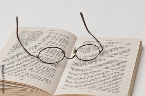 Glasses with black rounded frame on open book photo