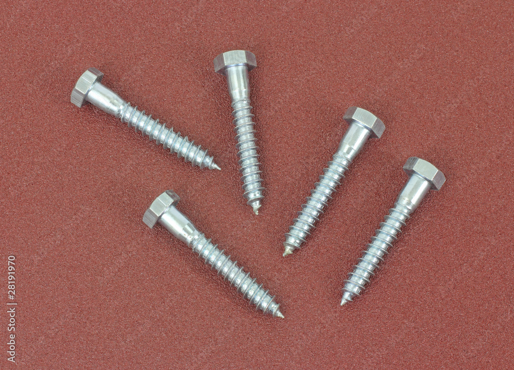 Group of stainless steel lag bolts on sandpaper Group of stainless steel lag bolts on sandpaper