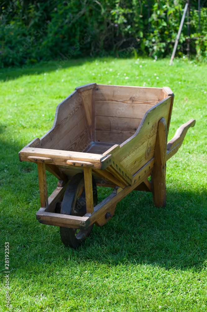 Wooden trolley on green grass in the garden