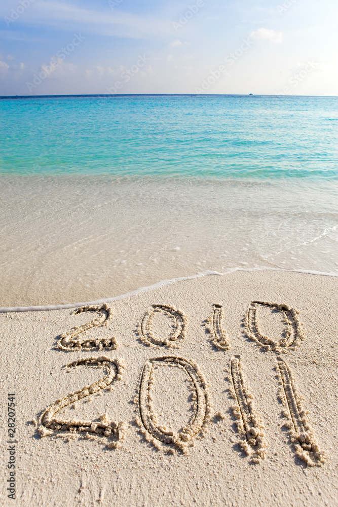 New 2011. The wave washes off an inscription 2010 New 2011. The wave washes off an inscription 2010