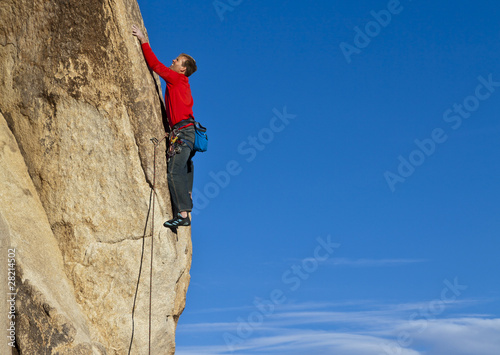 Climber clinging to a cliff.