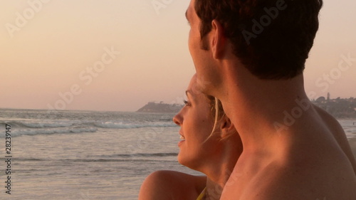 Young couple kissing on beach at sunset