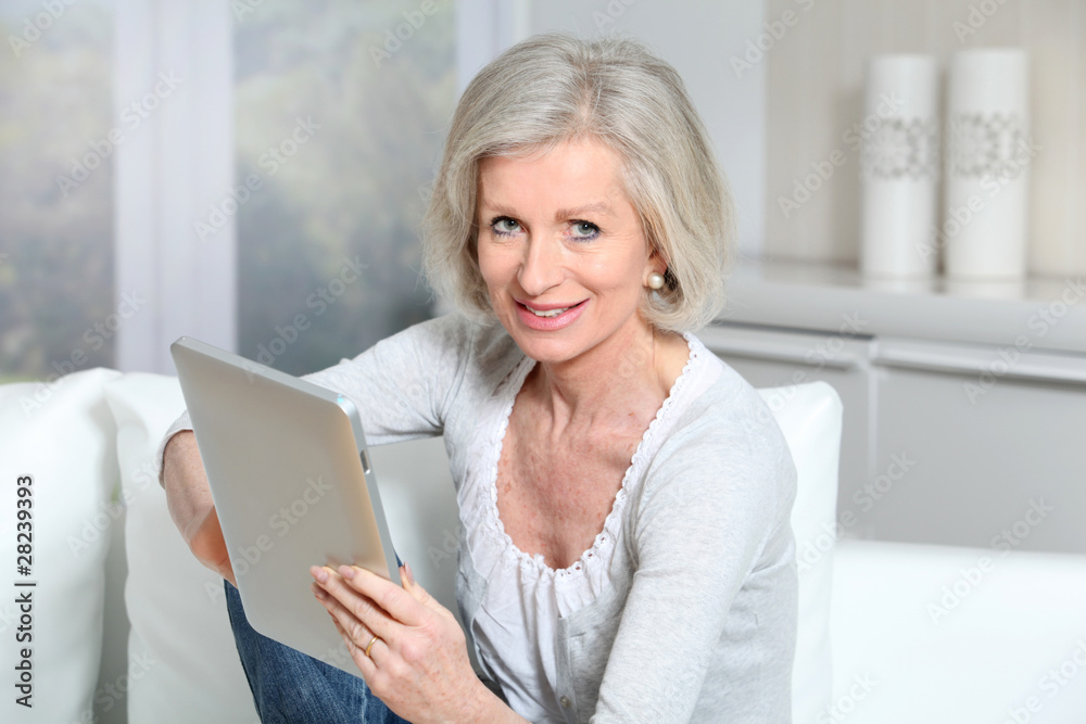Closeup of senior woman sitting on sofa with electronic pad Closeup of senior woman sitting on sofa with electronic pad