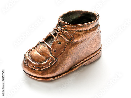 Single babyshoe on white background, bronze