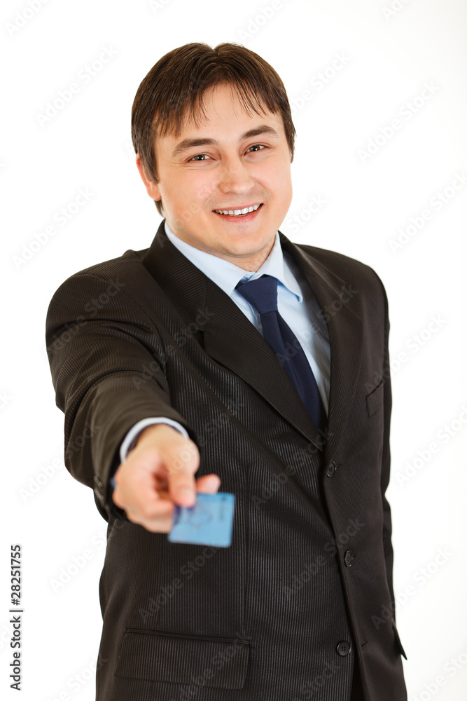 Smiling young businessman giving credit card isolated on white. Smiling young businessman giving credit card isolated on white.