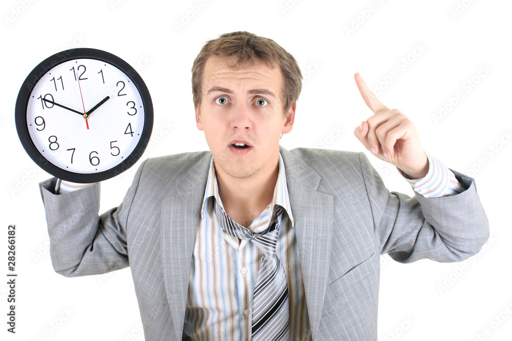 Amazed businessman in grey suit holding a clock Amazed businessman in grey suit holding a clock