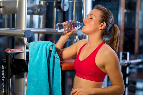 woman in gym drinks water