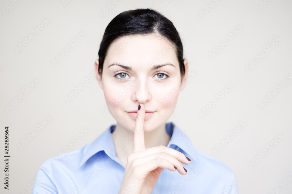 junge geschäfts frau legt geheimnisvoll finger auf lippen junge geschäfts frau legt geheimnisvoll finger auf lippen