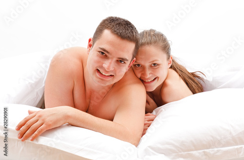 Happy young naked couple in bed